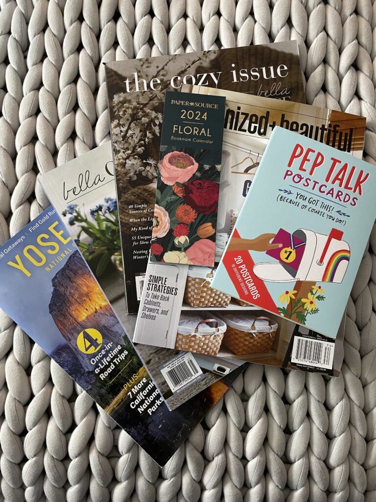 Pile of magazines and printed images spread out on a table for creating a midlife vision board