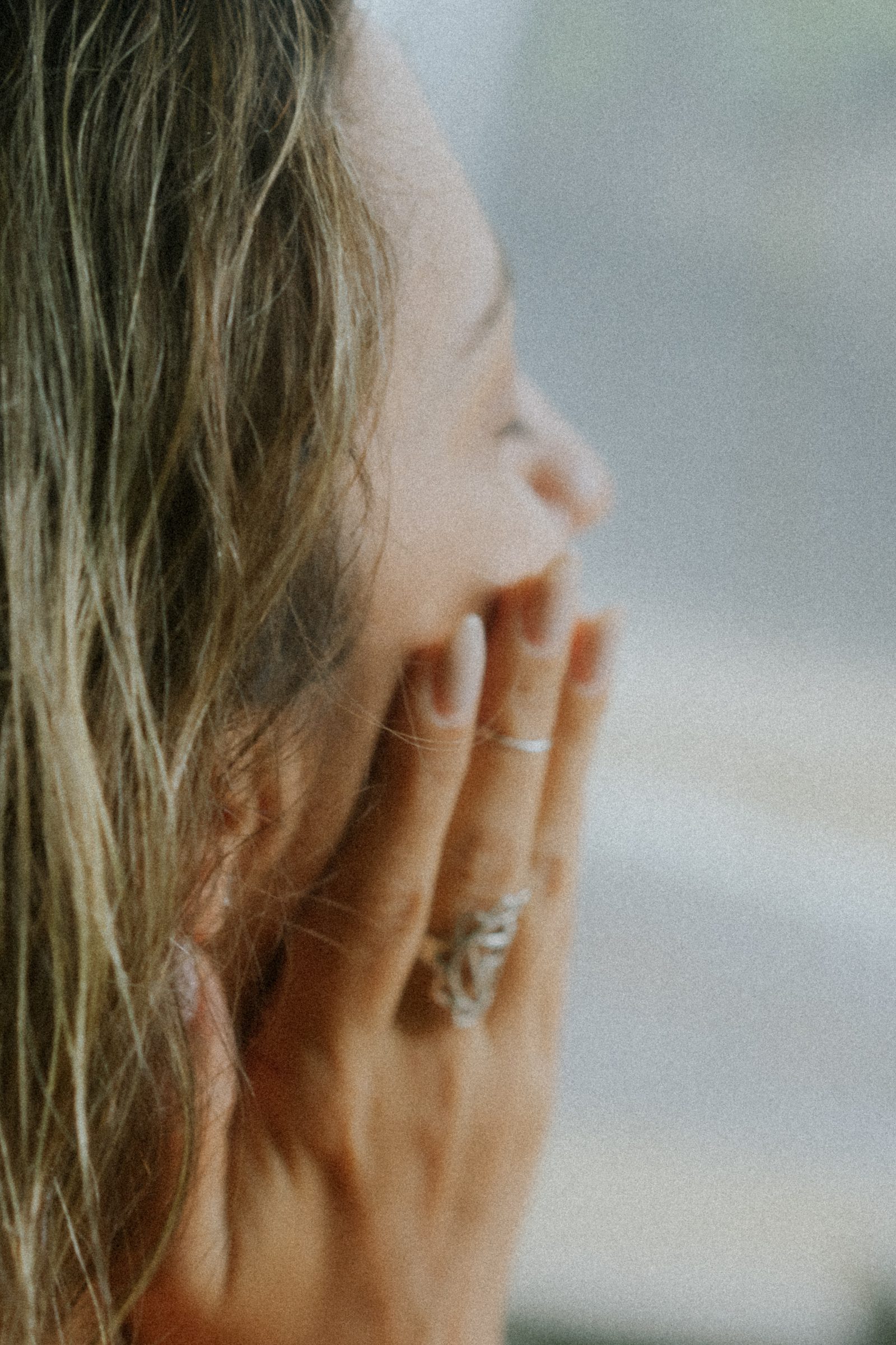 A woman in her forties laughing while holding a coffee, giving cozy midlife energy and representing the relatable tone of the Xennial experience.
