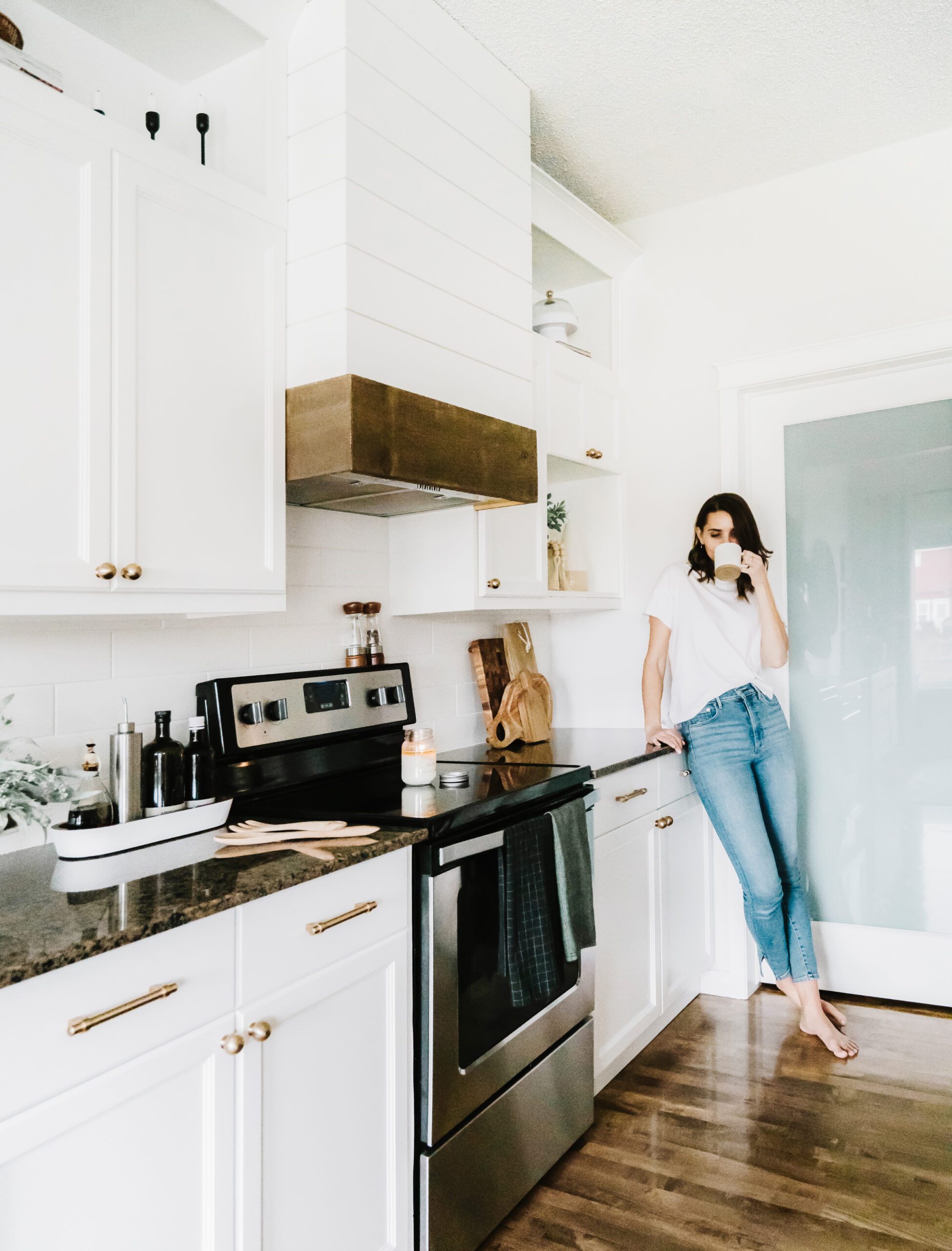midlife woman sipping coffee in kitchen