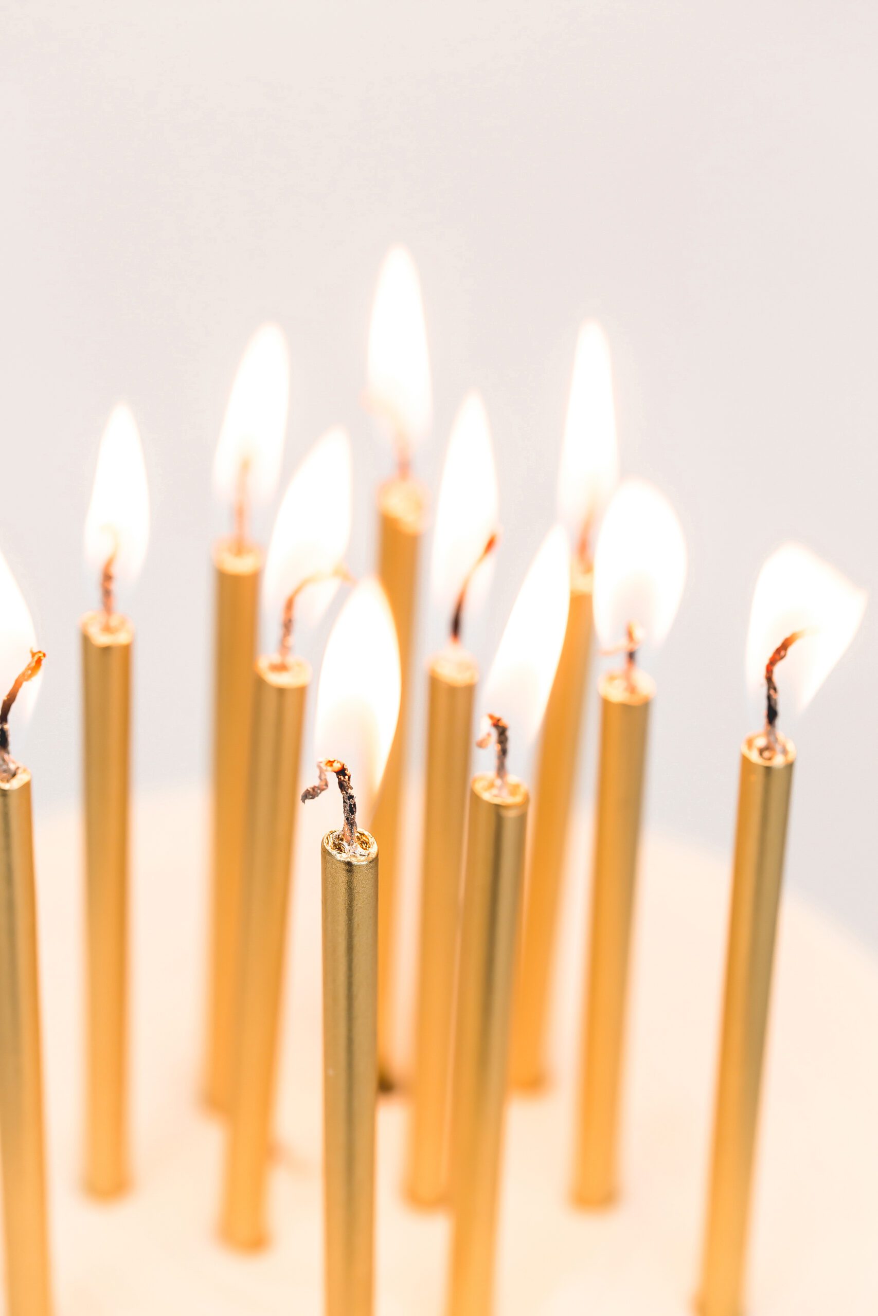 gold lit candles on a birthday cake