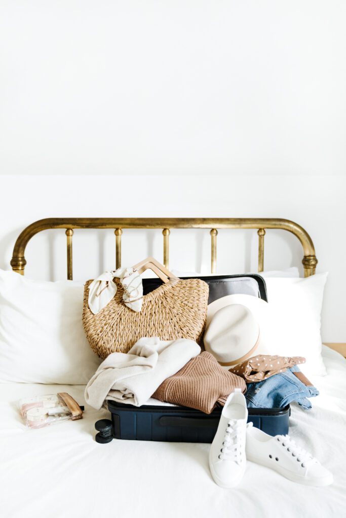packing a suitcase on a gold antique bed with white bedding
