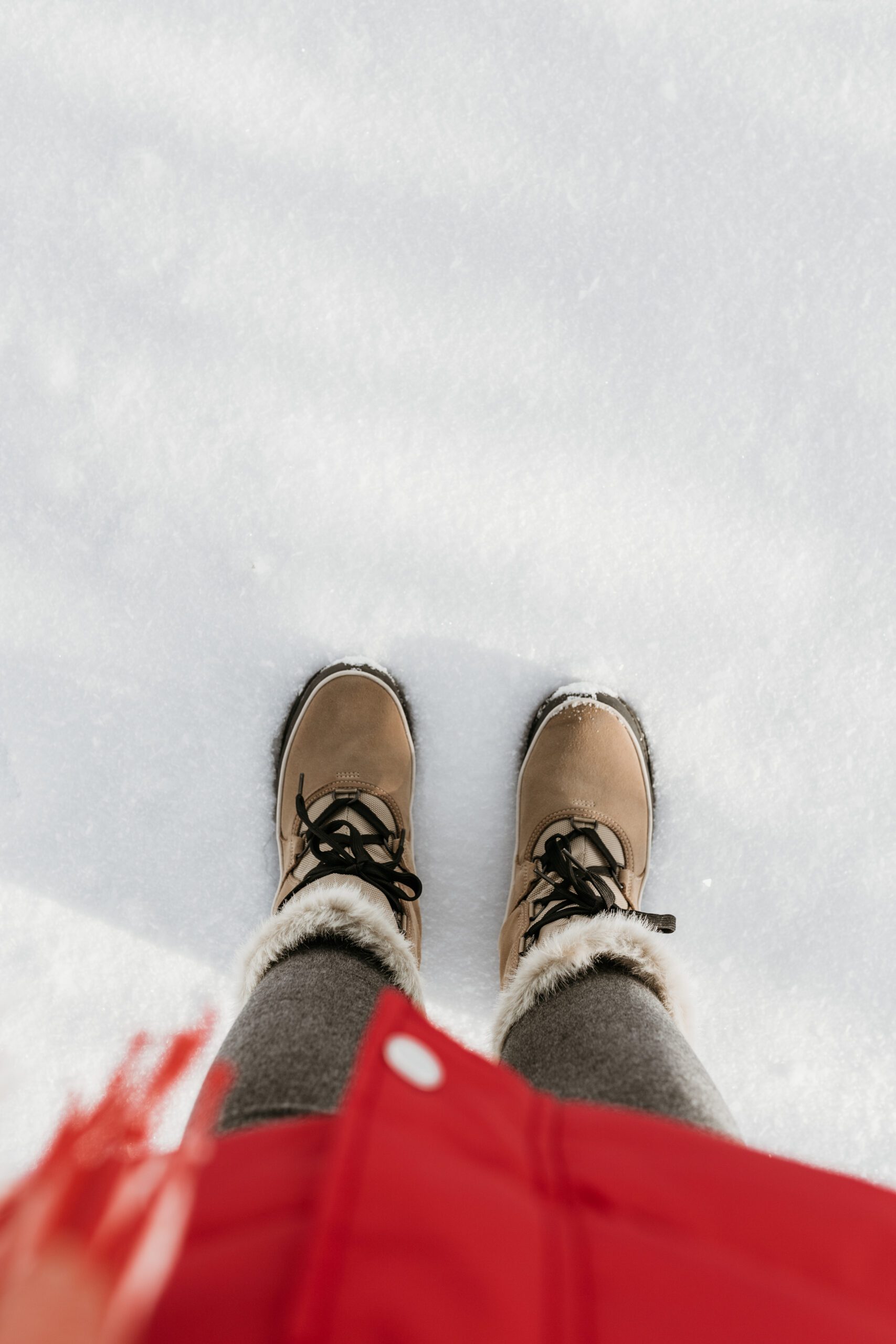 warm boots standing in snow with red coat